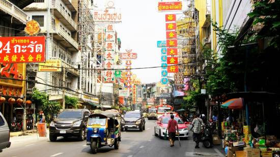 Busy daytime street in central Bangkok with cafes and shops