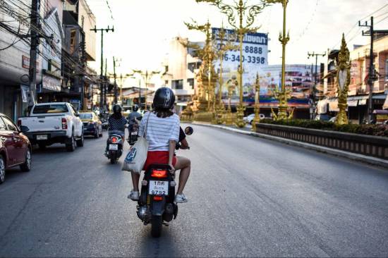 Young woman riding a scooter through Chiang Rai, Thailand, where the Thai term kathoey comes from